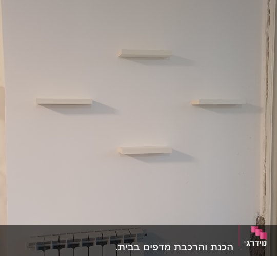 מדפים לבנים מותקנים על קיר לבן
